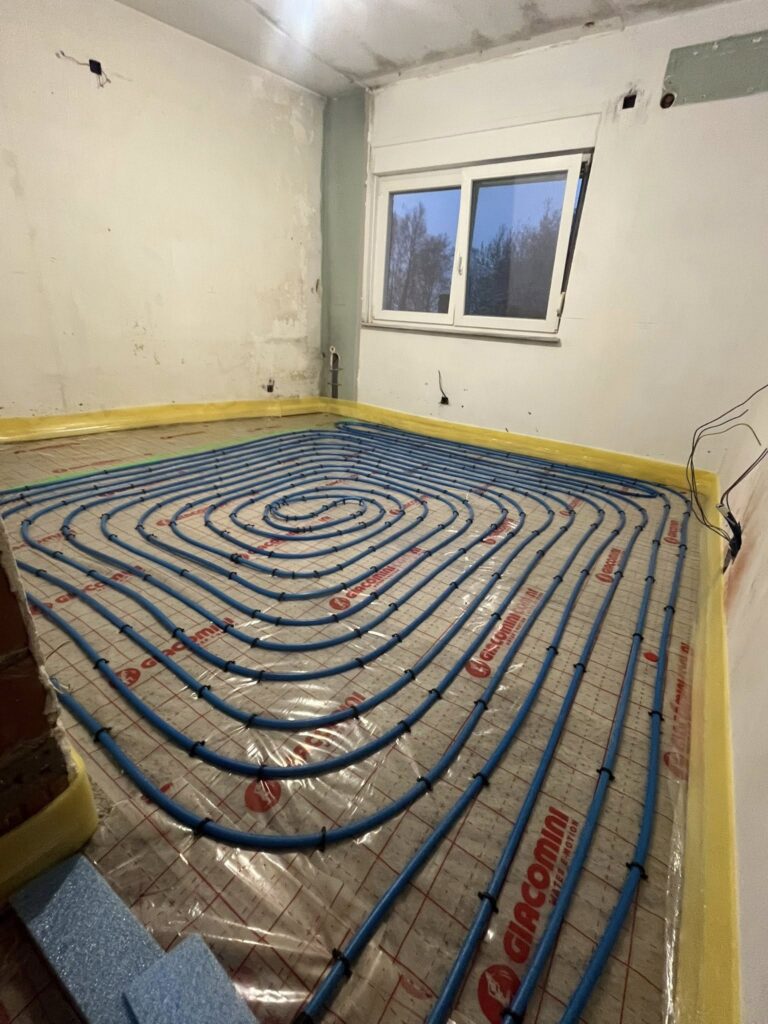 Project van vloerverwarming in woning met blauwe verwarmingsleidingen en collector voor energiezuinige verwarming
