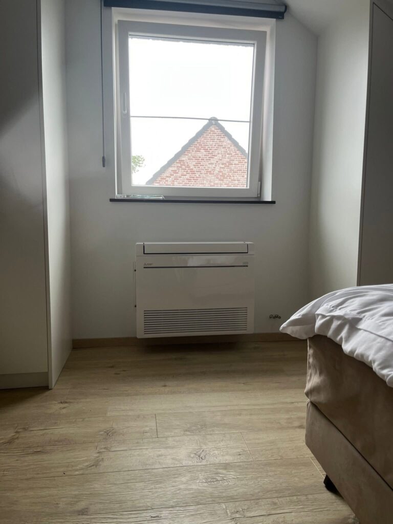 Vloermodel airco geplaatst onder het raam in een slaapkamer te Herzele door LLT