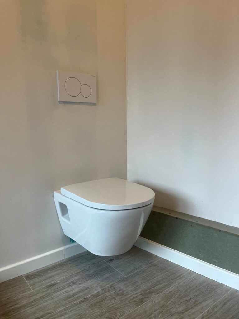 Hangtoilet met inbouwreservoir en bedieningsplaat geplaatst door LLT