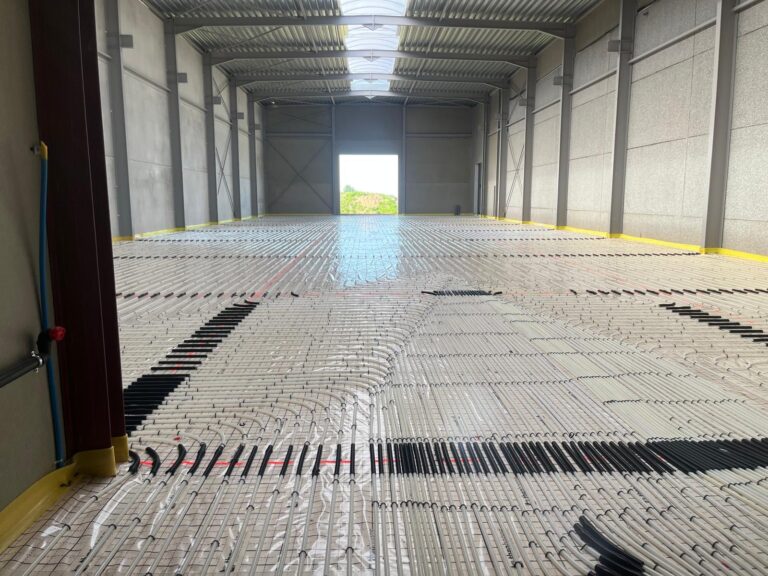 Vloerverwarmingsleidingen aangelegd over de volledige oppervlakte van een KMO-gebouw door LLT